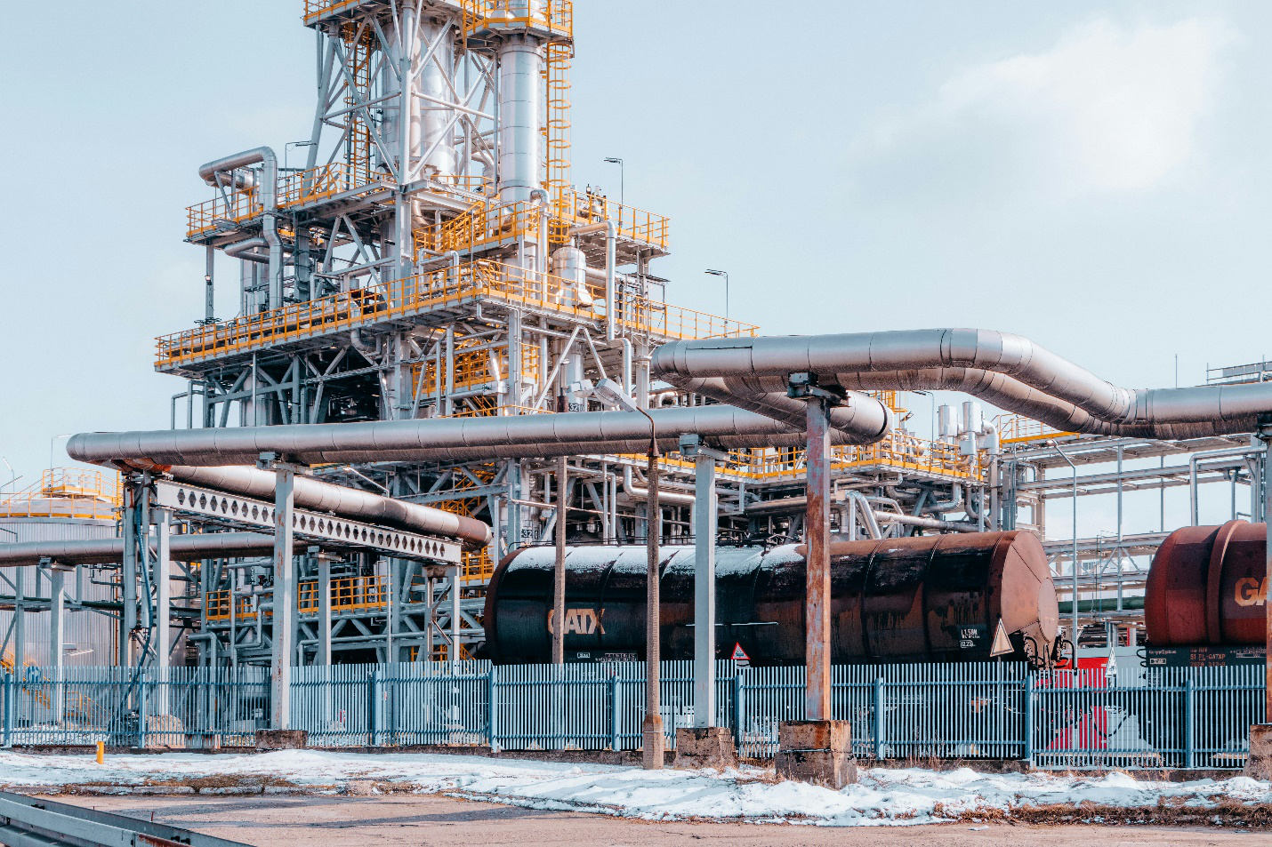 Tanker wagons parked at an oil refinery symbolizing the need for refinery management services.